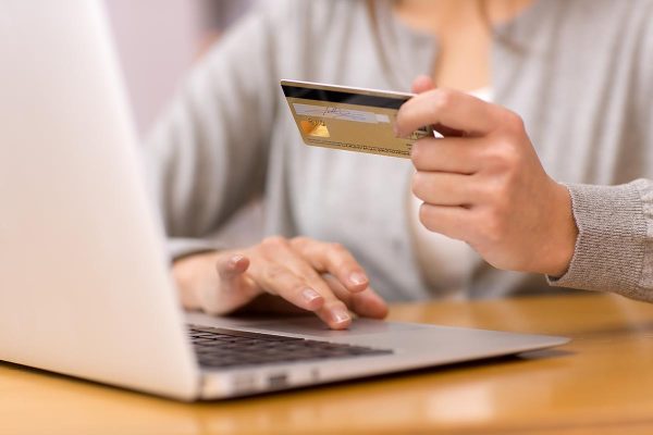 Close-up,Woman's,Hands,Holding,A,Credit,Card,And,Using,Computer